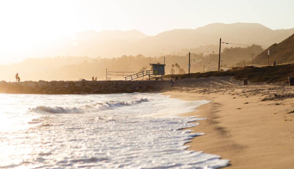 Sandy shoreline and gentle waves at Malibu Lagoon Beach during golden hour