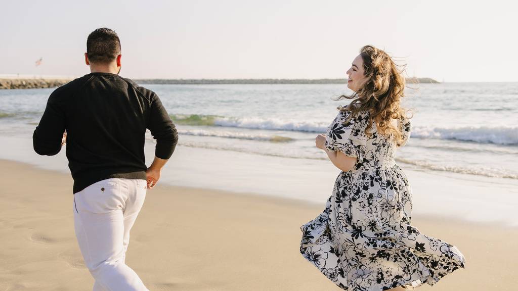running on beach engagement photo