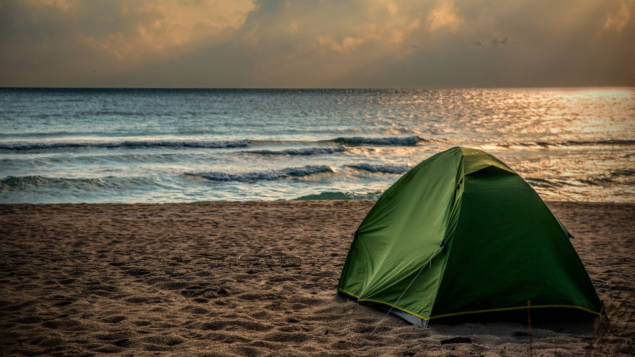 green beach tent at sunset by the ocean green beach tent at sunset by the ocean