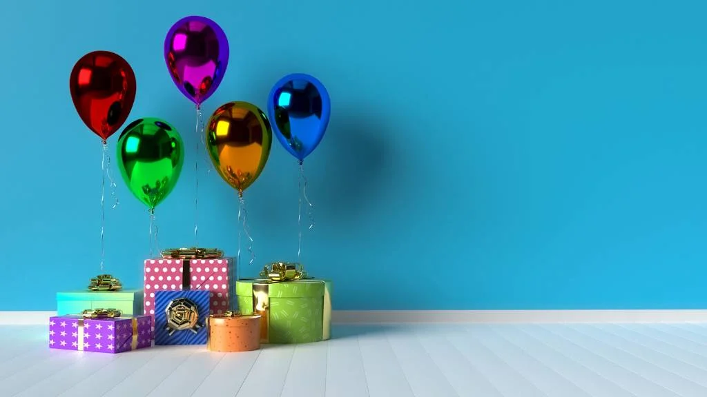 Colorful helium balloons with gifts against blue wall