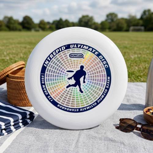 Duncan Competition Disc on a picnic blanket beside an open park field