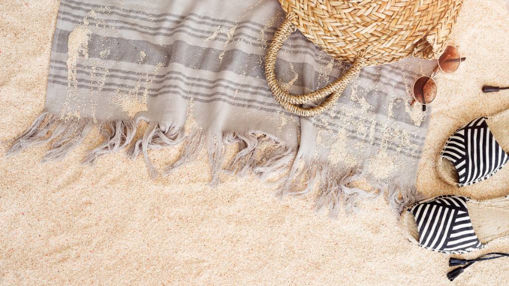 neutral fringed beach towel with beach accessories