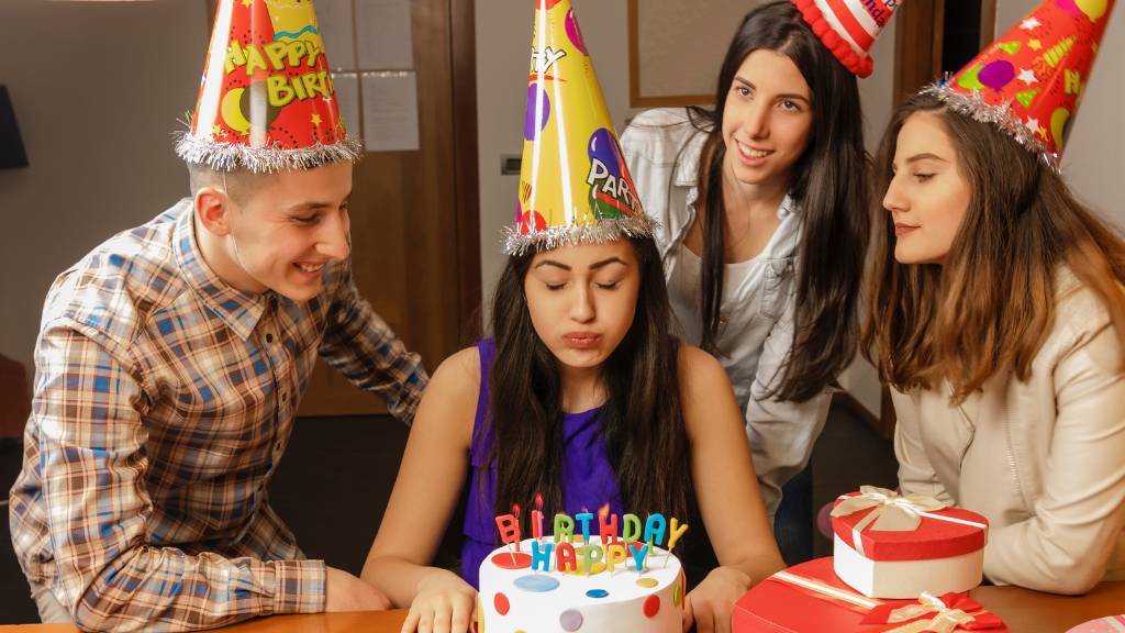 daughter-in-law blowing out candles at birthday party with friends