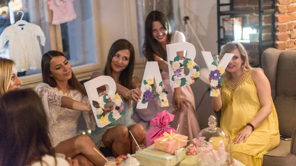 holding baby letters at cozy baby shower