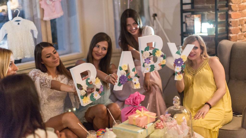 holding baby letters at cozy baby shower