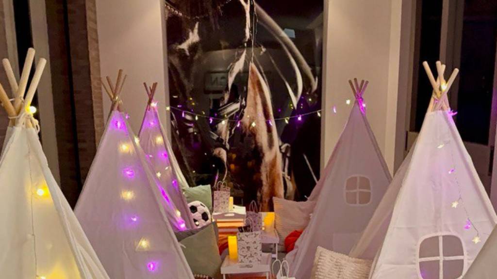 white tents with fairy lights and soccer ball decor