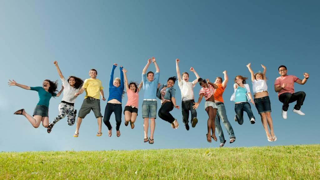 Happy students jumping in the air after a fun college picnic