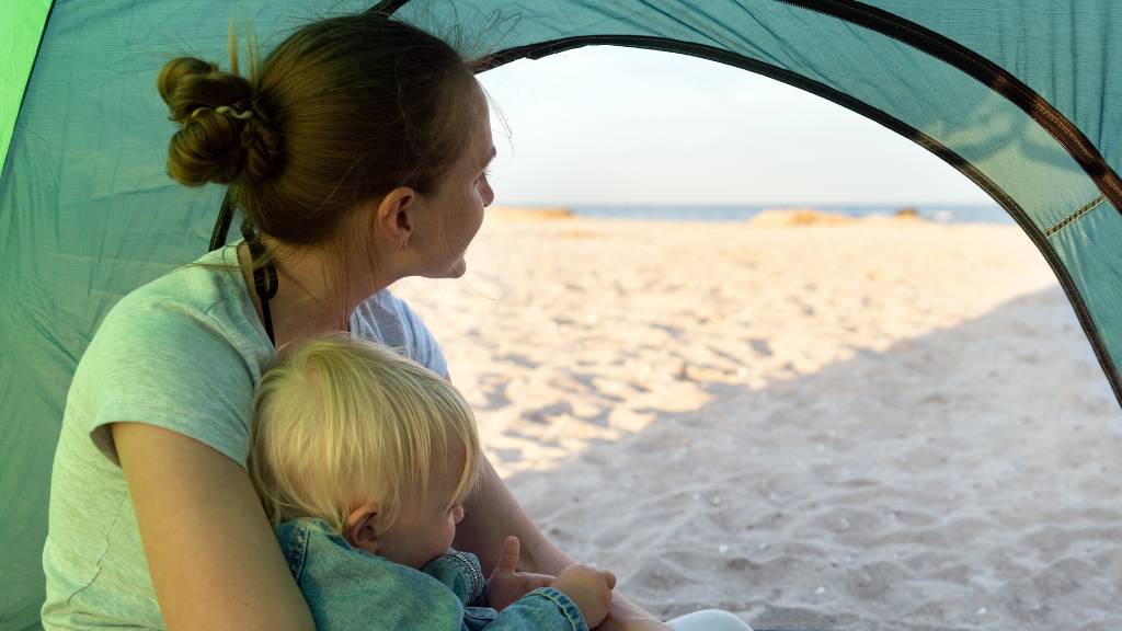 baby and a mother in a beach tent
