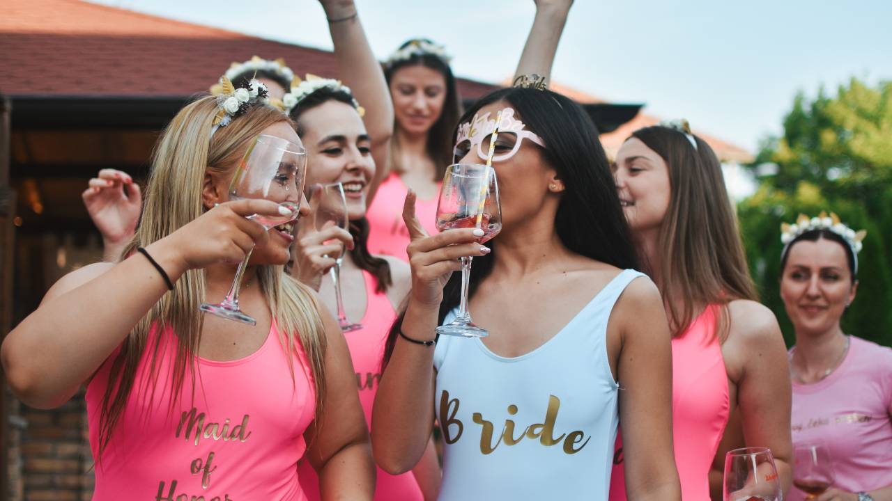 bride and bridesmaids toasting in swimsuits