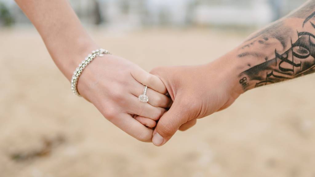 couple holding hands ring