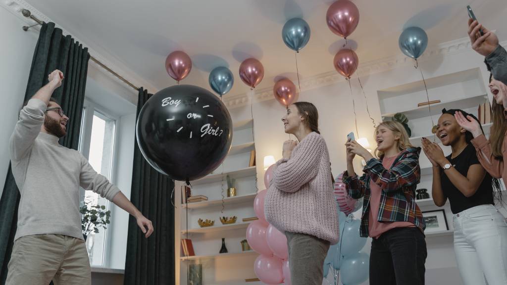 siblings with balloon pop reveal