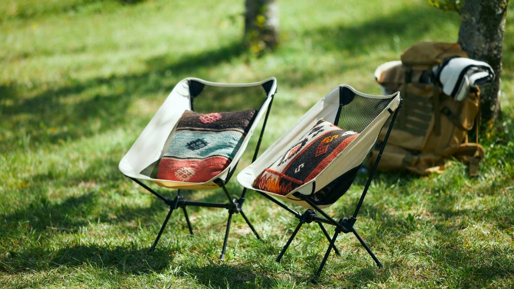 picnic setup with two chairs and backpacks on grass