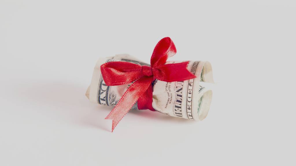 rolled cash gift with red ribbon