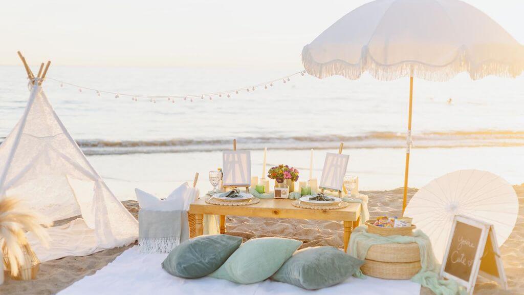 beach picnic setup with low table and pillows