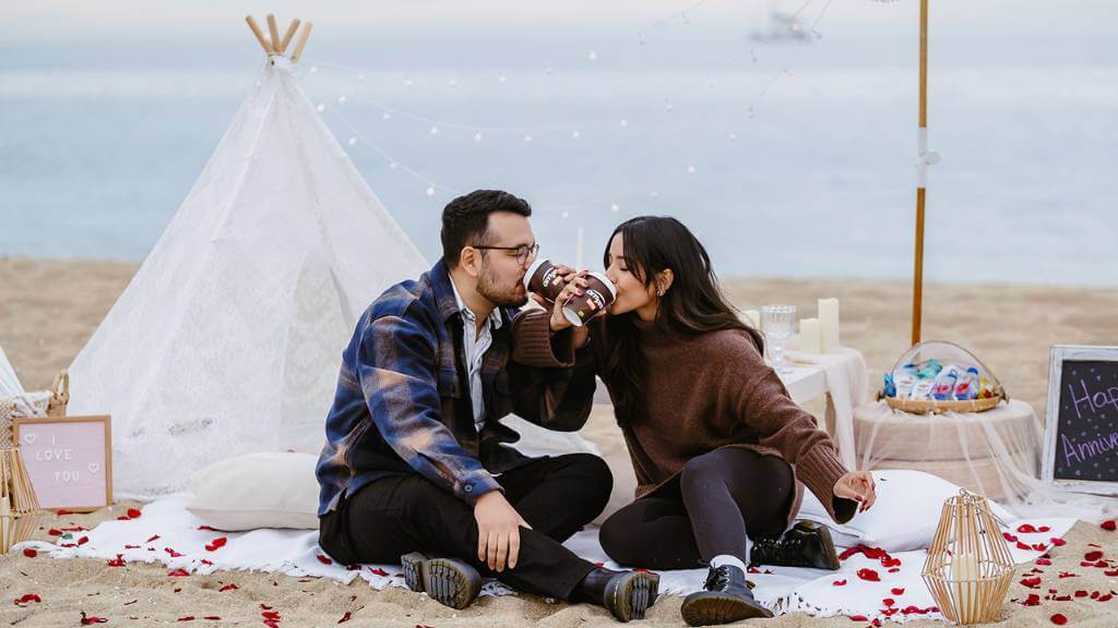 married couple at romantic beach picnic