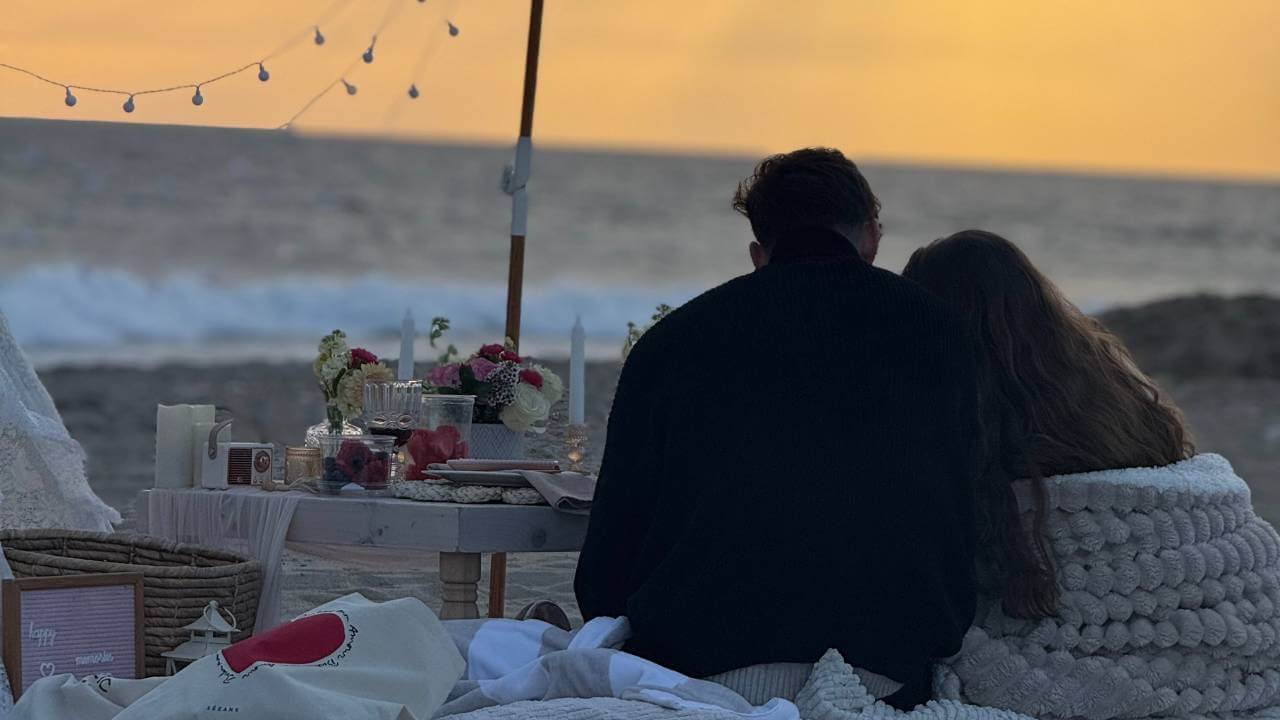 couple relaxing at sunset beach picnic